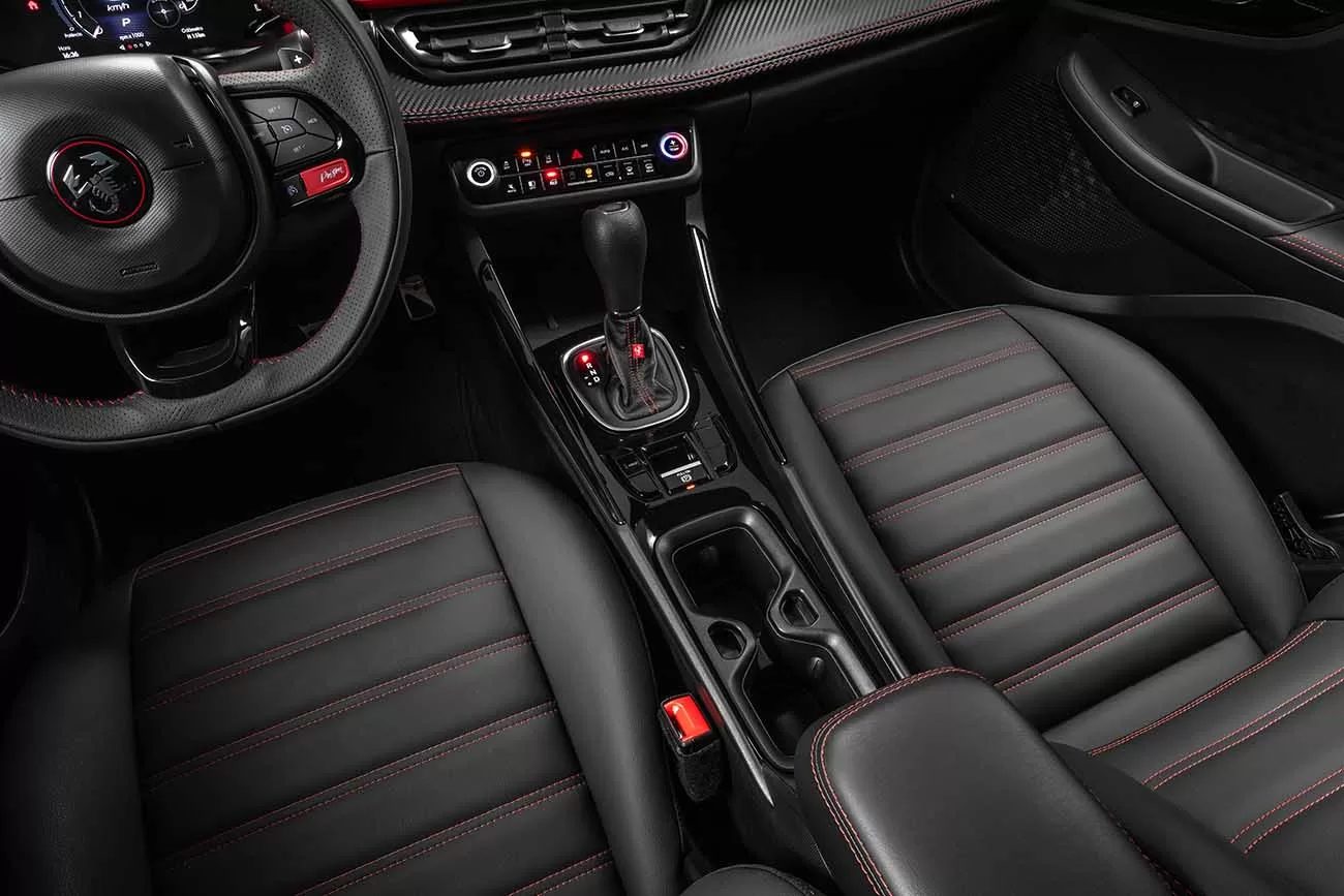 O interior do Fastback Abarth oferece conforto premium, com bancos de couro ecológico e detalhes em vermelho que criam uma atmosfera luxuosa e esportiva.