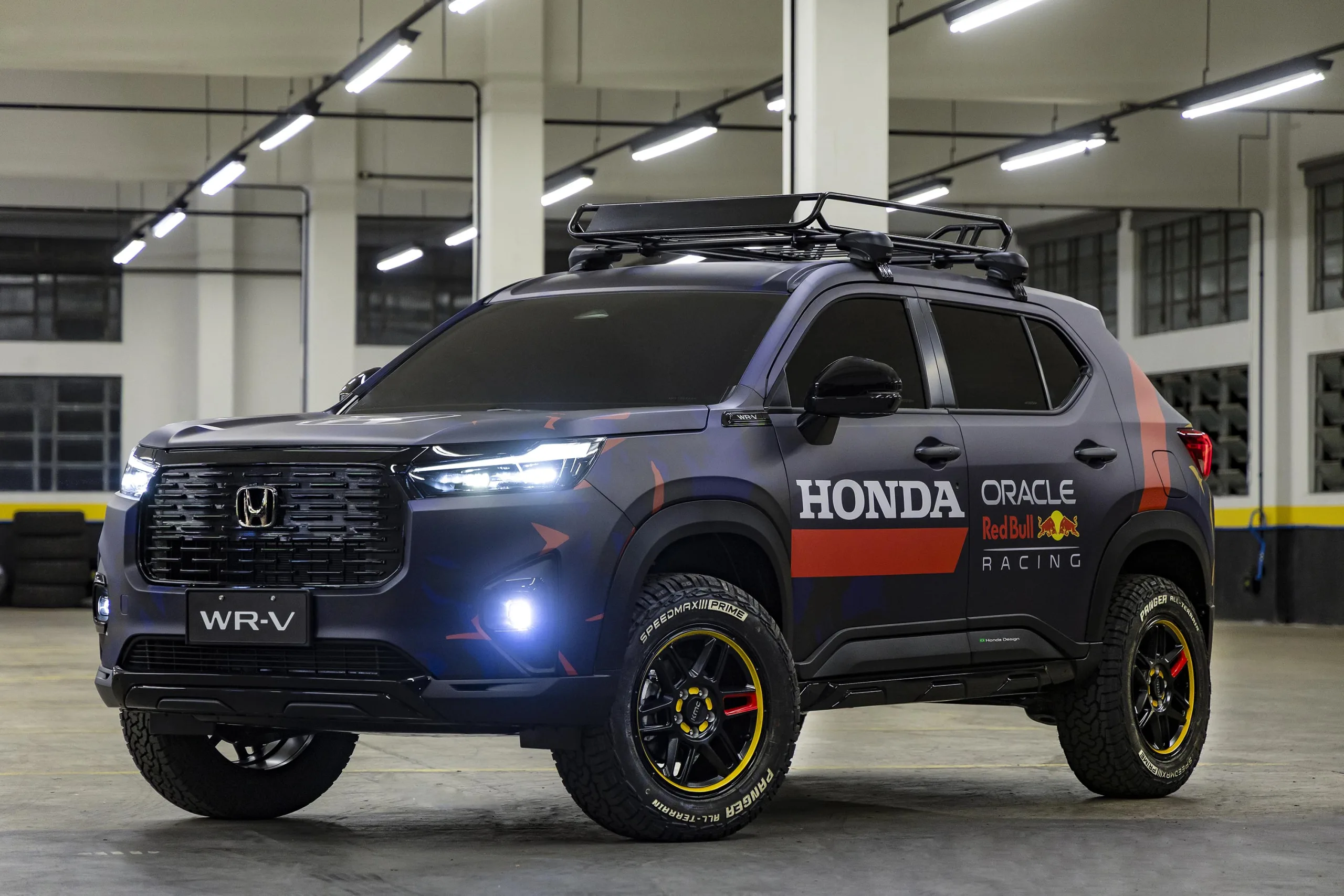 O modelo traz uma pintura azul e vermelha que remete às cores do time austríaco, combinada a detalhes escurecidos na grade, nas rodas e nos para-choques. As rodas de liga leve aro 17 e o rack de teto reforçam o visual aventureiro, enquanto os pneus de uso misto dão mais robustez ao conjunto.